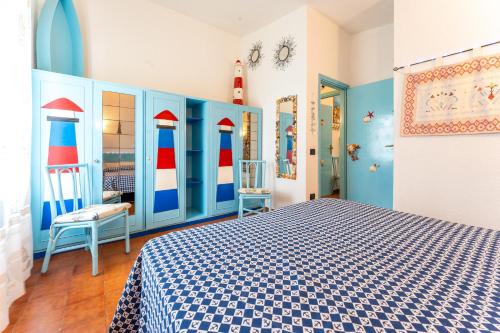 a bedroom with a blue and red bed and a chair at Villa Tiziana in Costa Rei