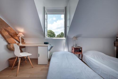 une chambre avec un lit, un bureau et une fenêtre dans l'établissement Les Robinsons de Versailles, central et verdoyant, à Versailles