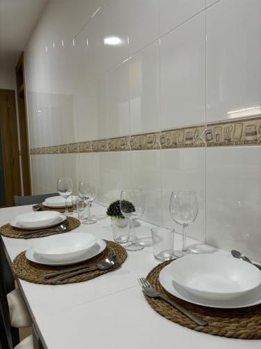 a table with plates and wine glasses on it at Alesamar A in Burela de Cabo