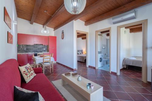 a living room with a red couch and a table at Estremo Sud - Marzamemi Candy in Marzamemi