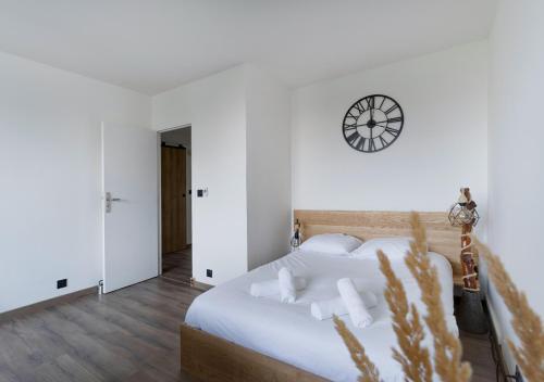 - une chambre dotée d'un lit avec une horloge murale dans l'établissement Grand studio proche tram et Stade de France, à Saint-Denis