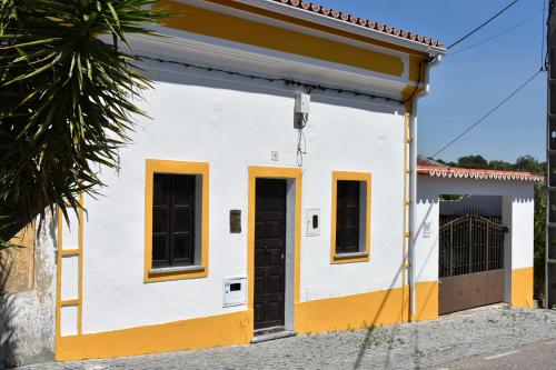 a white and yellow building with two doors at Casa da Aldeia by Portus Alacer in Arez