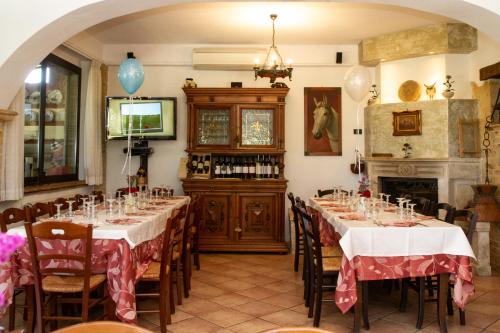 ein Esszimmer mit 2 Tischen und einem Kamin in der Unterkunft Agriturismo La Collinetta in Brecciarola