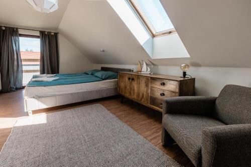 a bedroom with a bed and a chair and a window at Dom mazurski z basenem in Rydzewo