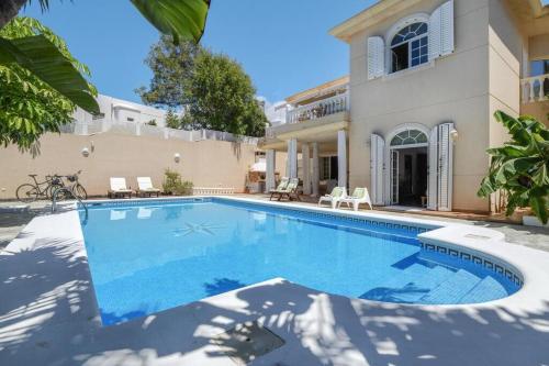 a swimming pool in front of a house at Bayside Concha House - Beachfront Oasis with Heated Pool in Playa Honda