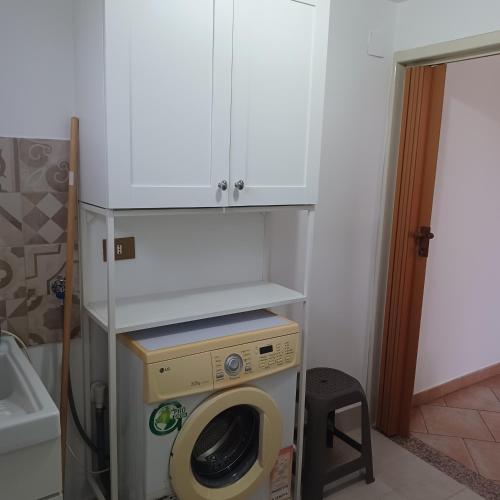 a washer and dryer in a kitchen with a cabinet at Casa vacanza ' A casa dei Nonni 2 ' in Belpasso