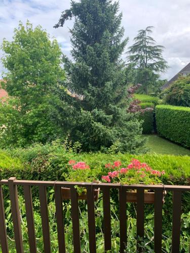 un jardin avec des fleurs roses et une clôture en bois dans l'établissement Etage maison, accès indépendant, au Mans