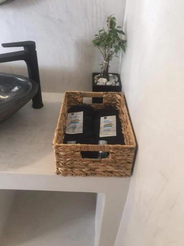 a basket sitting on a table with a plant in it at Darsi suites Kythnos in Kithnos