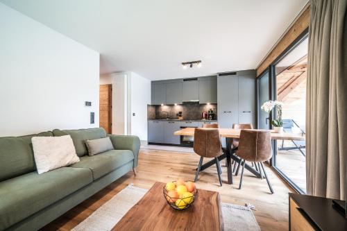 un salon avec un canapé vert et une table dans l'établissement Apartment Primerose Les Gets - by EMERALD STAY, aux Gets