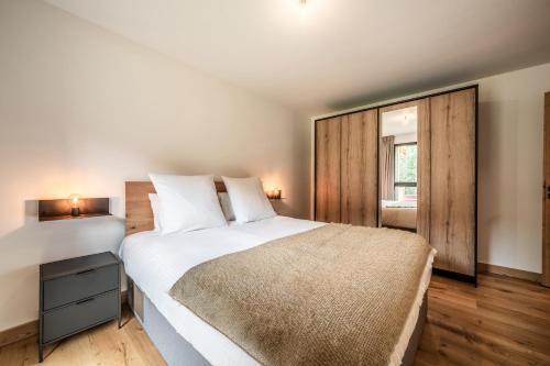 une chambre avec un grand lit blanc et une fenêtre dans l'établissement Apartment Primerose Les Gets - by EMERALD STAY, aux Gets