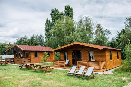 a cabin with a picnic table and chairs in front of it at Domki nad Odrą Wały in Brzeg Dolny