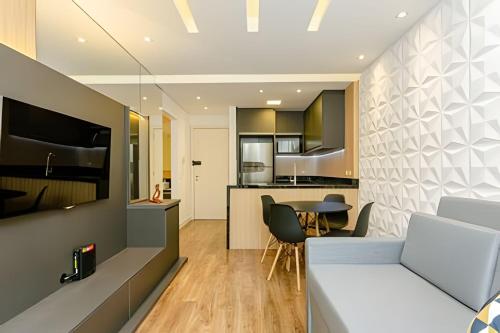 a kitchen and living room with a couch and a table at Sky Batel - Apartamentos UROOMS in Curitiba