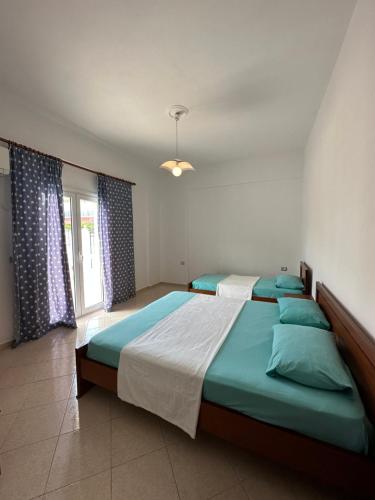a bedroom with a large bed and a window at Guesthouse Agalliu in Ksamil