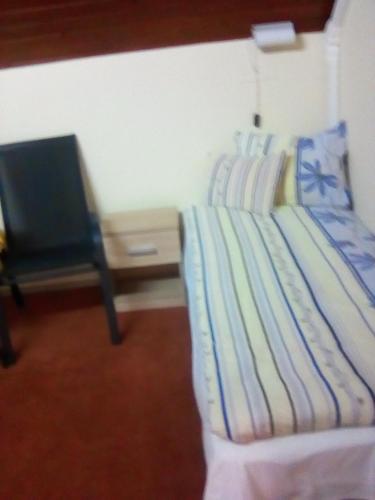 a bedroom with a bed with a chair and a desk at Ilona Vendégház in Siófok