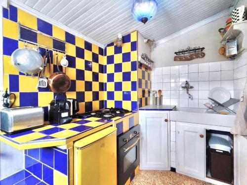 une cuisine avec un mur à damier dans l'établissement La Maisonette Cambon, Charme en Camargue, à Saintes-Maries-de-la-Mer