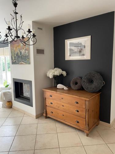 - un salon avec une commode en bois et une cheminée dans l'établissement Maison avec piscine entre plage et montagne, à Laroque-des-Albères