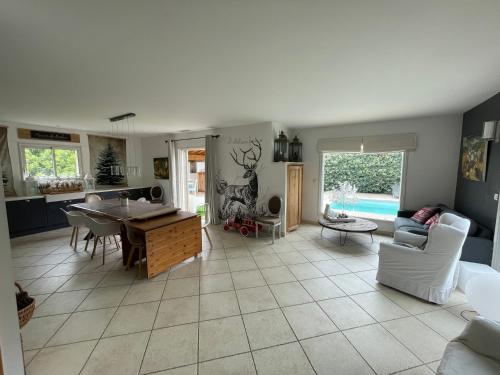 une cuisine et un salon avec une table et des chaises dans l'établissement Maison avec piscine entre plage et montagne, à Laroque-des-Albères