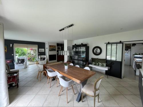 une cuisine et une salle à manger avec une table et des chaises en bois dans l'établissement Maison avec piscine entre plage et montagne, à Laroque-des-Albères