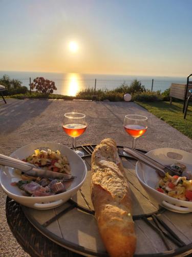 une table avec deux assiettes de nourriture et des verres de vin dans l'établissement Villa Acqua Doria, à Coti-Chiavari