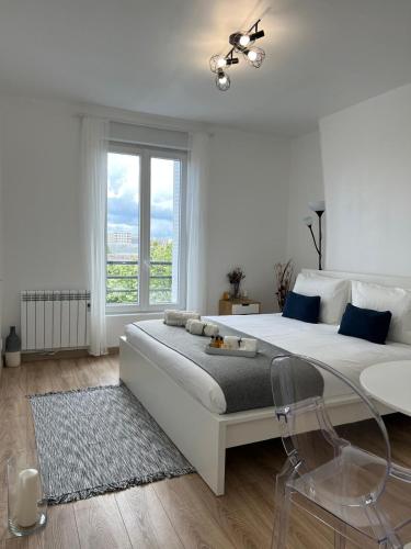 - une chambre blanche avec un grand lit et une table en verre dans l'établissement 