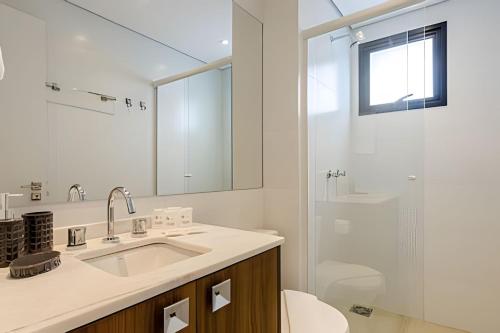 a white bathroom with a sink and a shower at Easy Emiliano - Apartamentos UROOMS in Curitiba
