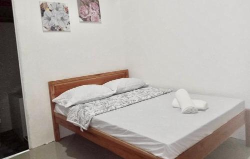 a bed with white sheets and pillows on it at Jazz Ferme Inn Batuan Bohol in Batuan