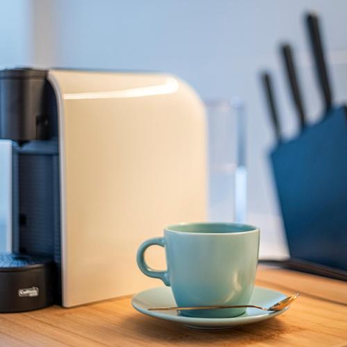a cup on a plate next to a coffee maker at Chalet Marias - Parede beach apartments in Parede