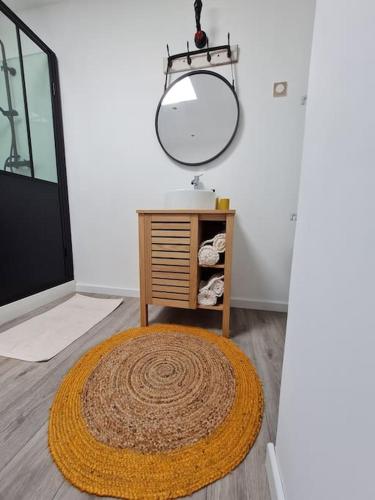 - une salle de bains avec un miroir et un tapis au sol dans l'établissement Dépendance avec place de parking, à Sainte-Soulle