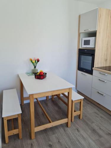 une cuisine avec une table avec un bol de fruits dessus dans l'établissement Dépendance avec place de parking, à Sainte-Soulle