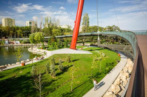a person walking on a swing bridge over a park at City Hotel Bucharest in Bucharest