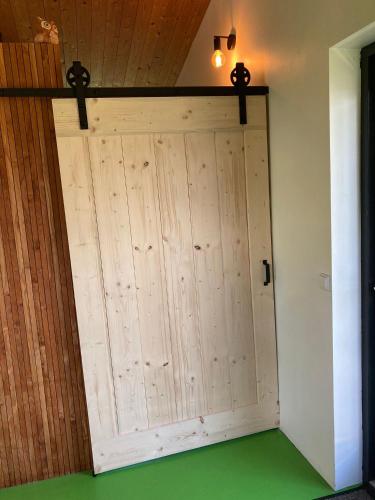 a large wooden garage door in a room with green floors at 't UijlenHuijs in Dussen