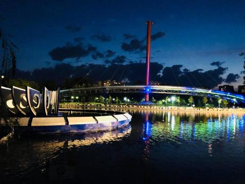 a bridge over a body of water at night at City Hotel Bucharest in Bucharest