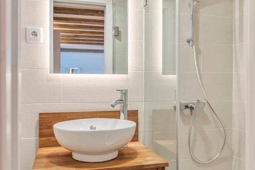 a bathroom with a white sink and a shower at Chalet Marias - Parede beach apartments in Parede