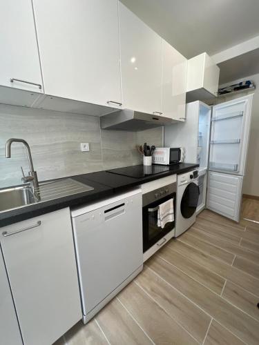 une cuisine blanche avec un évier et un lave-vaisselle dans l'établissement 