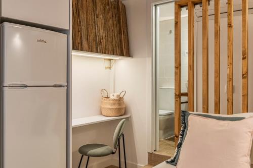 a small room with a refrigerator and a chair at Chalet Marias - Parede beach apartments in Parede
