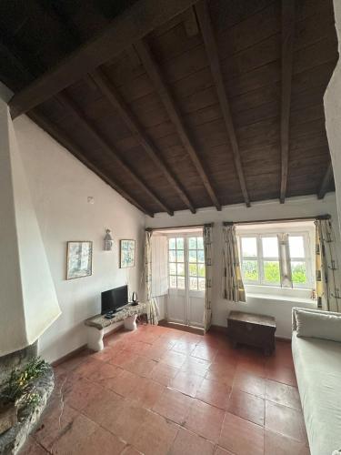 a living room with a wooden ceiling and windows at Casalinho do Farol, Serra da Arrábida in Setúbal