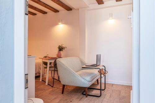 a room with a table and a chair and a computer at Chalet Marias - Parede beach apartments in Parede