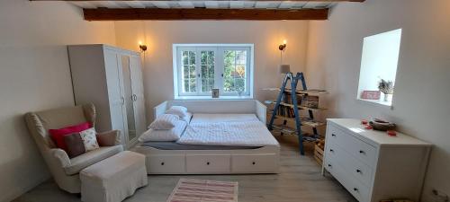 a bedroom with a bed and a chair and a window at GOfoREST - 150y Old Vintage Cottage Balaton - max 6 person in Várvölgy