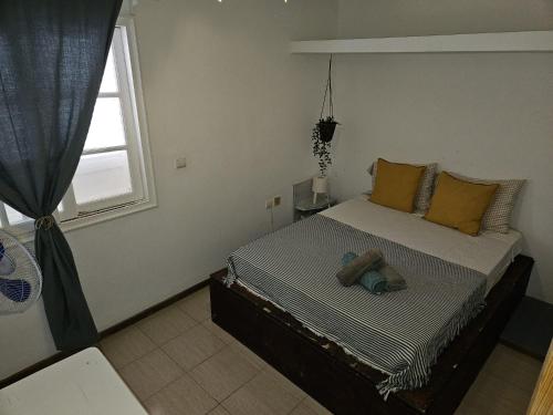 a small bedroom with a bed with a window at Casa Blu Guesthouse - Casa de Hospedes in Santa Maria