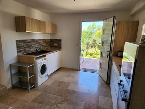 - une cuisine avec un lave-linge et un sèche-linge à côté d'une porte dans l'établissement La bastide des collines, à Allauch
