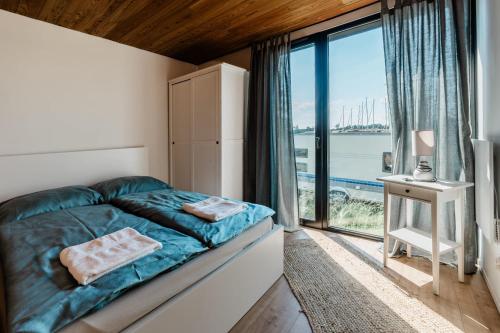 a bedroom with a bed and a large window at Domki Marina Rydzewo in Rydzewo