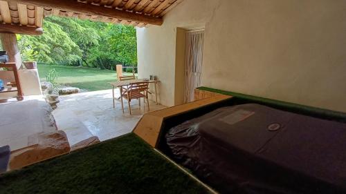 Cette chambre dispose d'un lit et d'une terrasse avec une table. dans l'établissement gîte nature campagne calme piscine spa, à Pierrevert