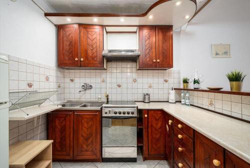 a kitchen with wooden cabinets and a stove top oven at Pereca 2 Rondo ONZ By Perfect Apart 801 in Warsaw