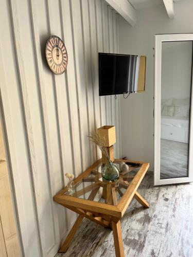 a room with a table and a clock on a wall at La Cabane Lacourrège in Urgosse