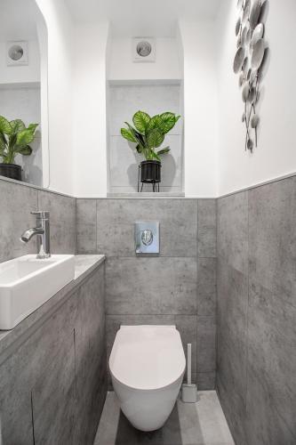 une salle de bain avec des toilettes blanches et un lavabo dans l'établissement Sweet-Bright, à Hayange