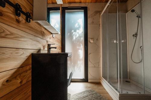 a bathroom with a glass shower and a sink at Domki Marina Rydzewo in Rydzewo