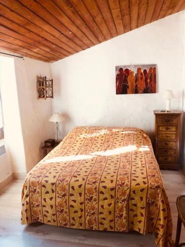 une chambre avec un lit et un plafond en bois dans l'établissement Gîte de la Placette, à Aumessas