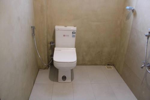 a bathroom with a white toilet in a stall at Holiday Home Ragama in Ragama