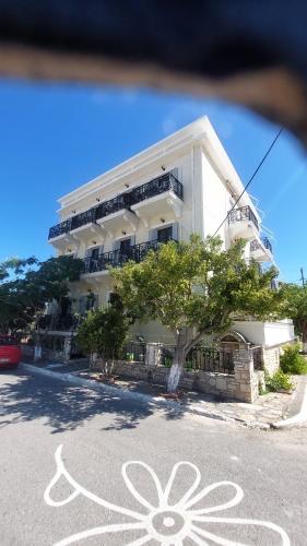 a white building with a flower painted on the street at HOTEL IREON beach in Samos