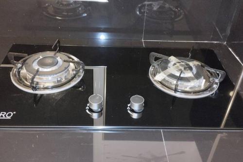 a stove with two pans on top of it at Holiday Home Ragama in Ragama
